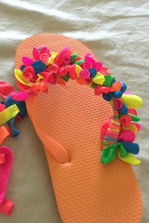 Love this summer project to make your own DIY decorated flip flops - all you'll need is a pack of water balloons! Mix and match patterns or make a rainbow pair. How to make these fun summer flip flops for kids (or adults) and just a few dollars!