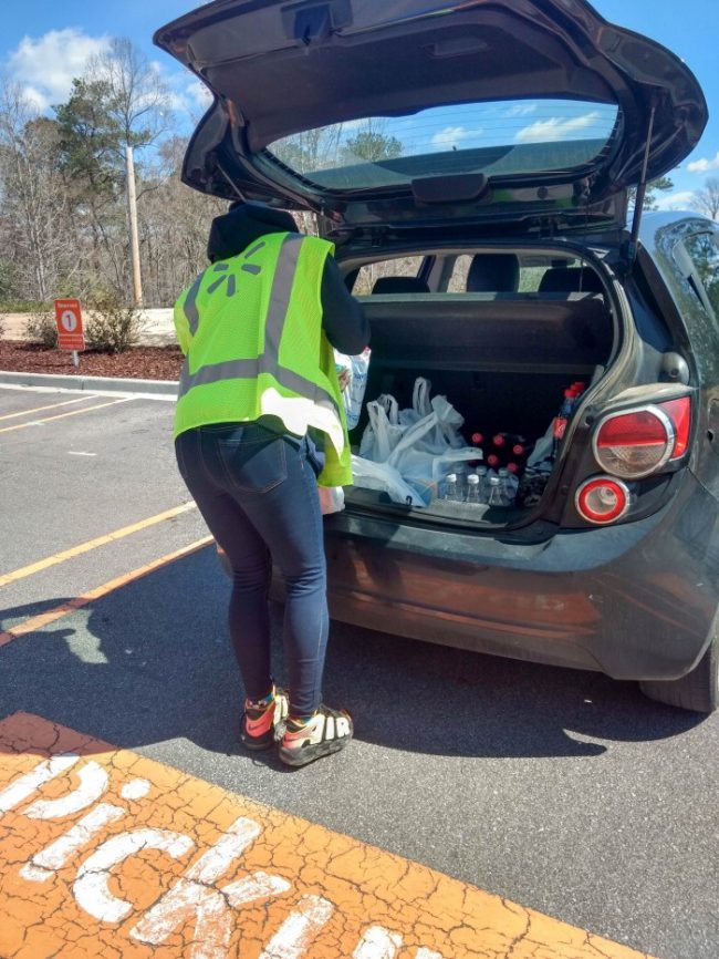 Walmart Grocery Pickup loading groceries into the trunk of a car