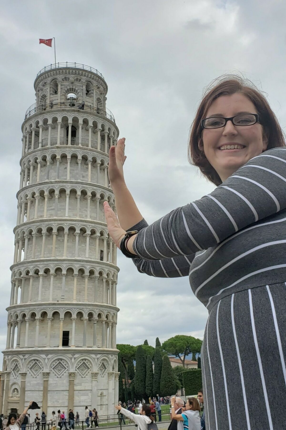 2 Week Switzerland & Italy Itinerary + Printable! holding up pisa leaning tower